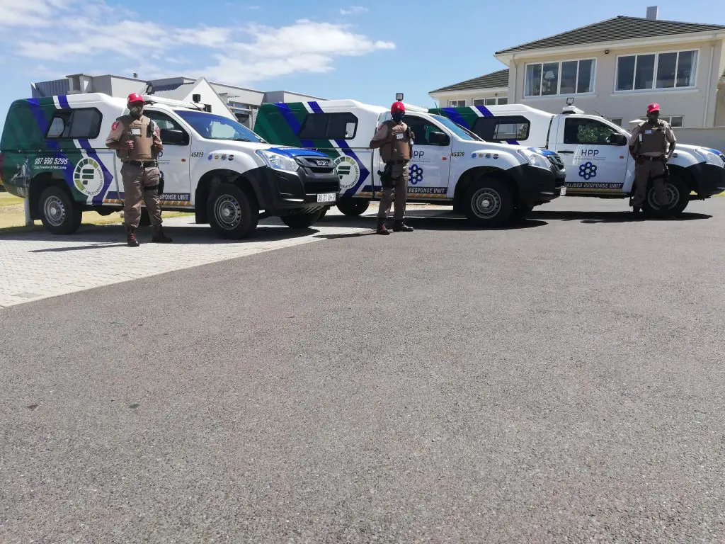 Armed security guards next to vehicles