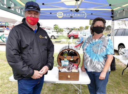 Two pople under a gazebo wearing masks